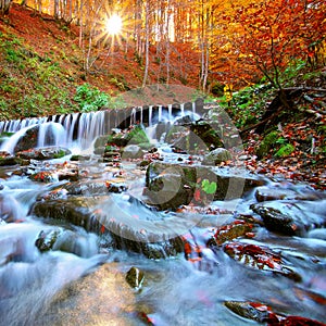 Beautiful waterfall in forest at sunset