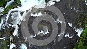 Beautiful waterfall in green forest, top view. River in a canyon, aerial drone Big Waterfall.