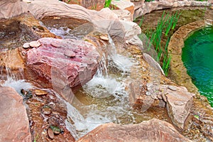 Beautiful waterfall,landscape design, water flows down a cliff into a pond, philosophy of life, feng-shui