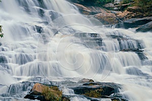 Beautiful waterfall in lush tropical forest, Chiang Mai, Thailand. Nature landscape. Long exposure of water falling on rock of