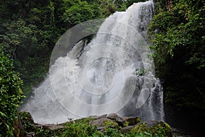 Beautiful Waterfall on the mountain and stream flowing on the rock of tropical rain forest in national park at Thailand