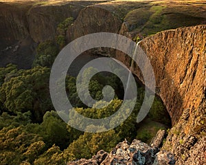 Beautiful waterfall over cliff at sunset