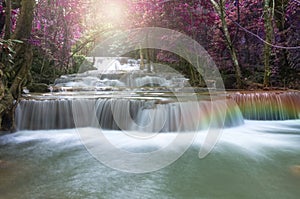 Beautiful waterfall in soft focus with rainbow in the forest