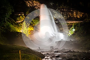 Beautiful waterfall Steinsdalsfossen in Norway shining lit up in the night