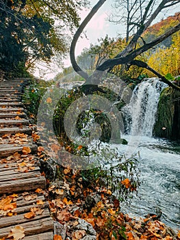 Beautiful waterfall and wooden stairs at famous Plitvice Lakes National Park in Croatia in autumn