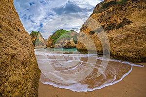 Beautiful wave in famous rock formation in a bay on the beach of Tres Irmaos in Alvor, PortimÃ£o, Algarve, Portugal, Europe.