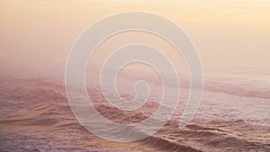 Beautiful Waves Breaking Ocean Seascape Background at Sunset, Pastel Muted Warm Orange Colours from