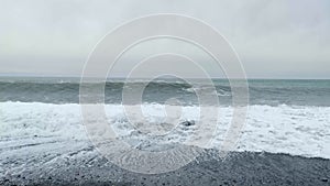 Beautiful waves and cloudy sky on pebble beach