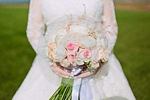 Beautiful wedding bouquet of flowers in hands of the bride