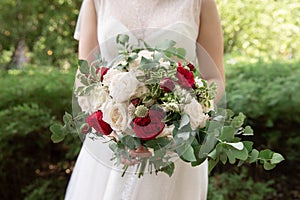 Beautiful wedding bouquet in the hands of the bride