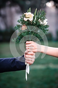 Beautiful wedding bouquet in the hands of the bride and groom