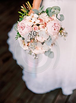 Beautiful wedding bouquet in the hands of the bride, modern stylish wedding concept, roses, peopy, eucaliptus, classic floristic s