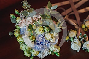Beautiful wedding bouquet with hydrangea and roses is lying on wooden background. Elegant decorative details. Blue and pastel