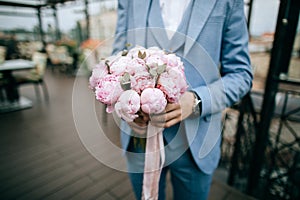 Beautiful Wedding bouquet of pink tulips in hands of groom