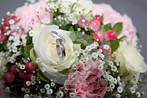 Beautiful wedding bouquet of pink and white flowers with marriage rings
