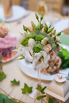 Beautiful wedding bouquet on a table of white and beige roses