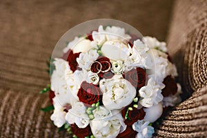 Beautiful wedding bouquet with white and purple flowers and wedding rings