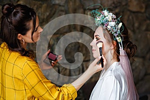 Beautiful wedding of the bride with makeup and hairstyle, a wreath in her hair and a veil. A professional makeup artist does the