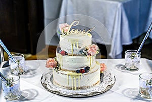 Beautiful wedding cake with cream With text Love on top pink flowers roses