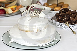 Beautiful wedding cake with cream With text Love on top white flowers roses