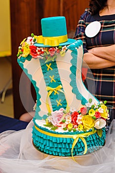 Beautiful wedding cake in turquoise colors with flowers and hat