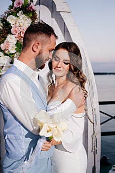 beautiful wedding ceremony by water on dock. bride and groom.