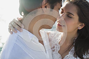 Beautiful wedding couple bride and groom on yacht at wedding day outdoors in the sea. Happy marriage couple kissing on