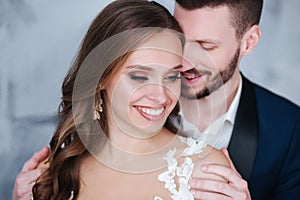 Beautiful wedding couple at home. They kiss and hug each other