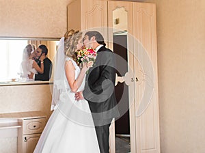 Beautiful wedding couple indoors. They kiss and hug each other