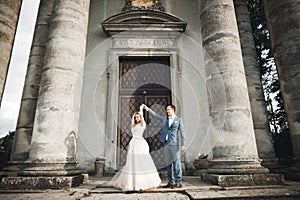 Beautiful wedding couple just married and dancing near old building