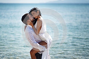 Beautiful wedding couple kissing and embracing in turquoise water, mediterranean sea in Greece.