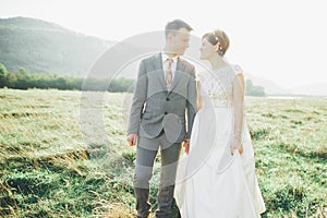 Beautiful wedding couple, love on the sunset. Fielf with view on mountains