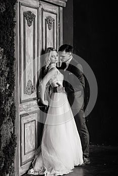 Beautiful wedding couple. Luxurious dress of the bride and stylish suit of the groom, studio photo shoot