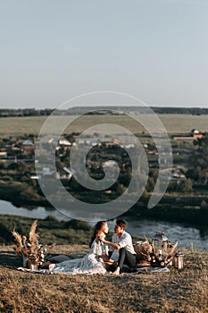 Beautiful wedding couple in nature in boho style. Wedding in the European style of fineart at sunset.