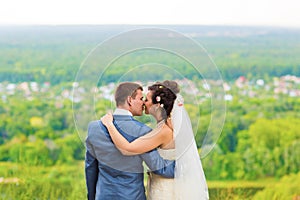 Beautiful wedding couple in park. kiss and hug