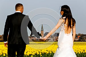Beautiful wedding couple posing in yellow field