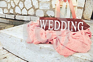 Beautiful wedding decoration on stony stairs with wooden arrow wedding. Big candle lanterns with pink flowers and