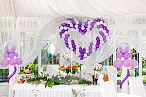 Beautiful wedding decorations. Heart of white and purple balloons on a celebratory table