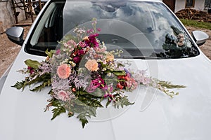 Beautiful wedding flowers on white luxurious car