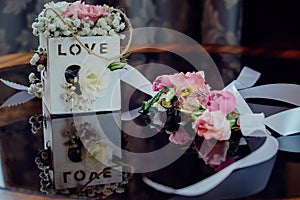 Beautiful wedding flowers in a wooden basket on a dark glass table