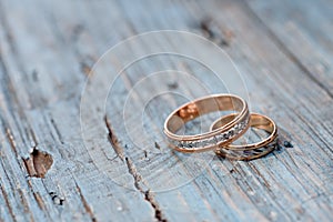 Beautiful wedding rings on a blue wooden background.