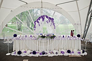 Beautiful wedding set decoration in the restaurant. Table of newlyweds outdoor tent