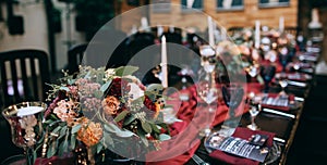 Beautiful weding table decoration with red fresh flowers and candles photo