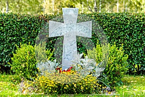Beautiful and well cared grave with white marble cross