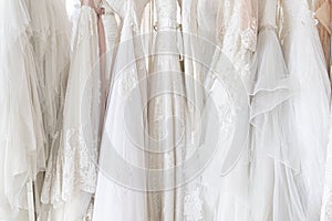 Beautiful, White bridal dress texture on background. Wedding dresses hanging on a hanger interior of bridal salon.