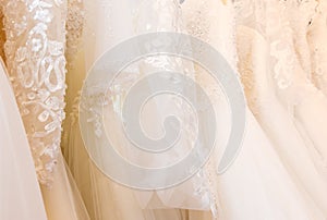 Beautiful, White bridal dress texture on background. Wedding dresses hanging on a hanger interior of bridal salon. Design, fashion
