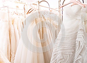 Beautiful, white bridal dress texture on background. Wedding dresses hanging on a hanger interior of bridal salon. Design, fashion