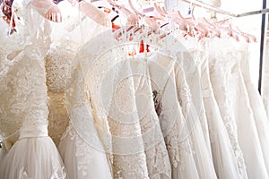 Beautiful, White bridal dress texture on background. Wedding dresses hanging on a hanger interior of bridal salon. Design, fashion