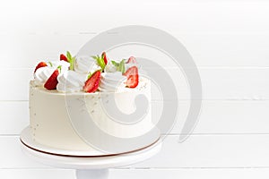 Beautiful white cake decoraited with meringue and fresh strawberries. White background