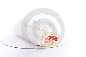 Beautiful white cake roll in front of a white background. The cake has snowflake-shaped confectionery decorations